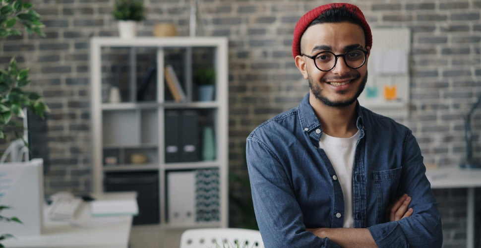 A man in smart-casual wear, smiling in an office setting