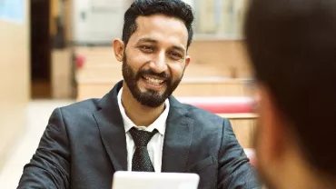 Person smiling while talking in an office setting.