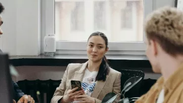 Three people having a discussion in an office.